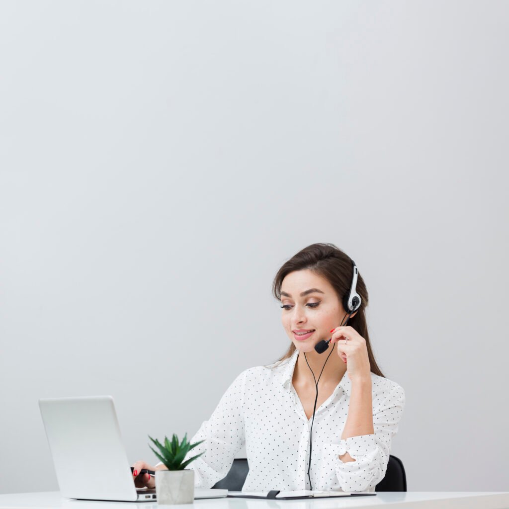 front view woman working desk while wearing headset looking laptop